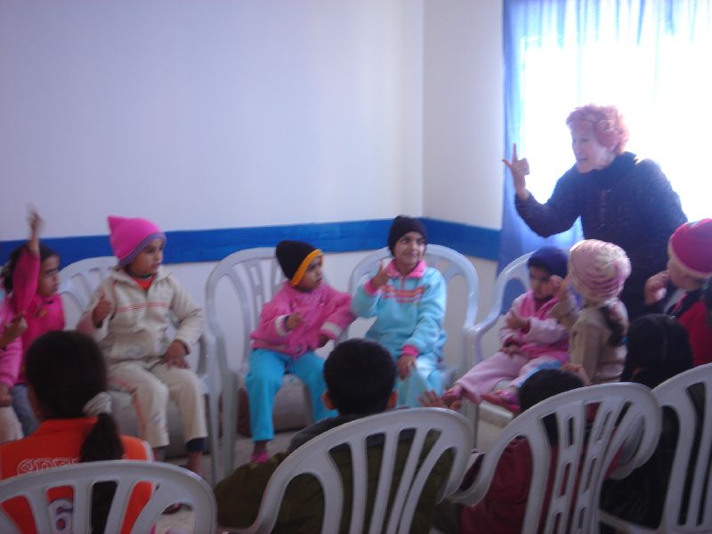 children in chairs with a lady speaking