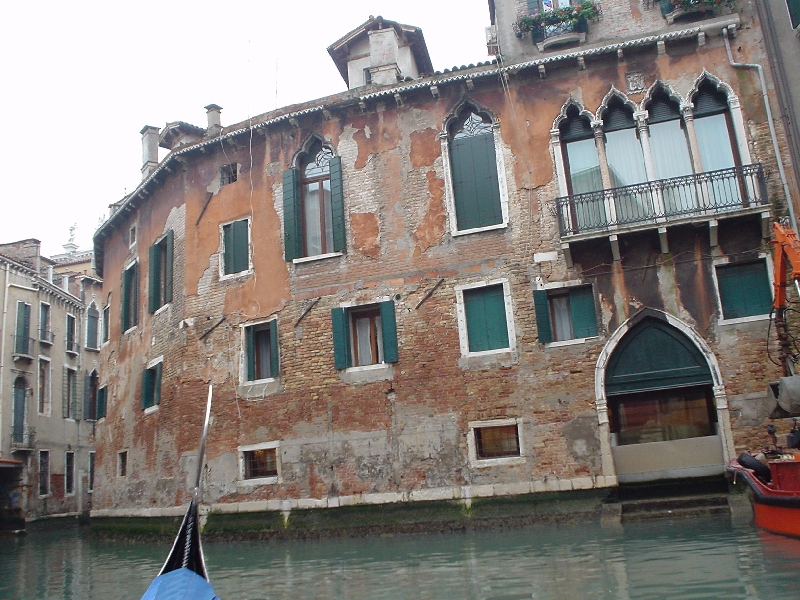 gondola sitting on the water in front of a house