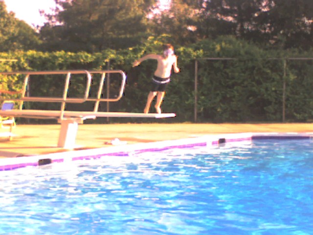 man in swimming pool with white boards on platform