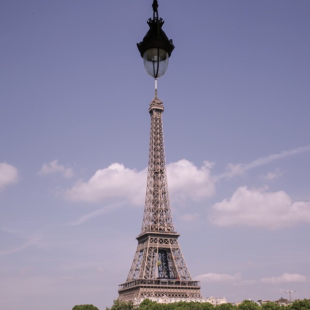 a tower with a clock is standing next to some bushes