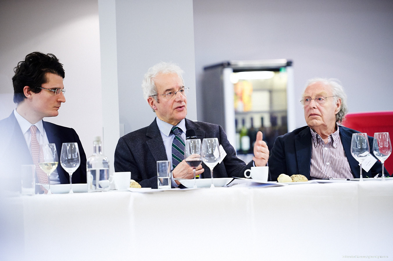 three people sitting around a table having drinks