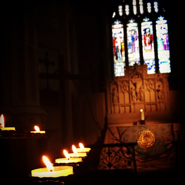 the lit candles are by the stained glass windows