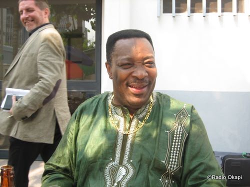 man in traditional african clothing laughing on a sidewalk