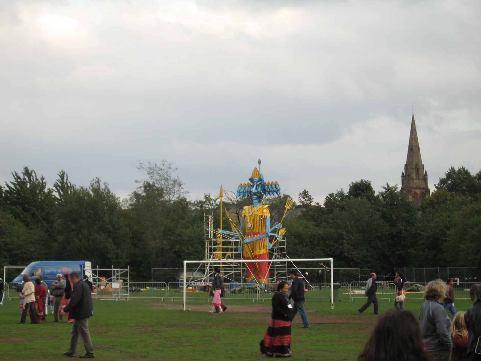 people stand in a park watching people play soccer