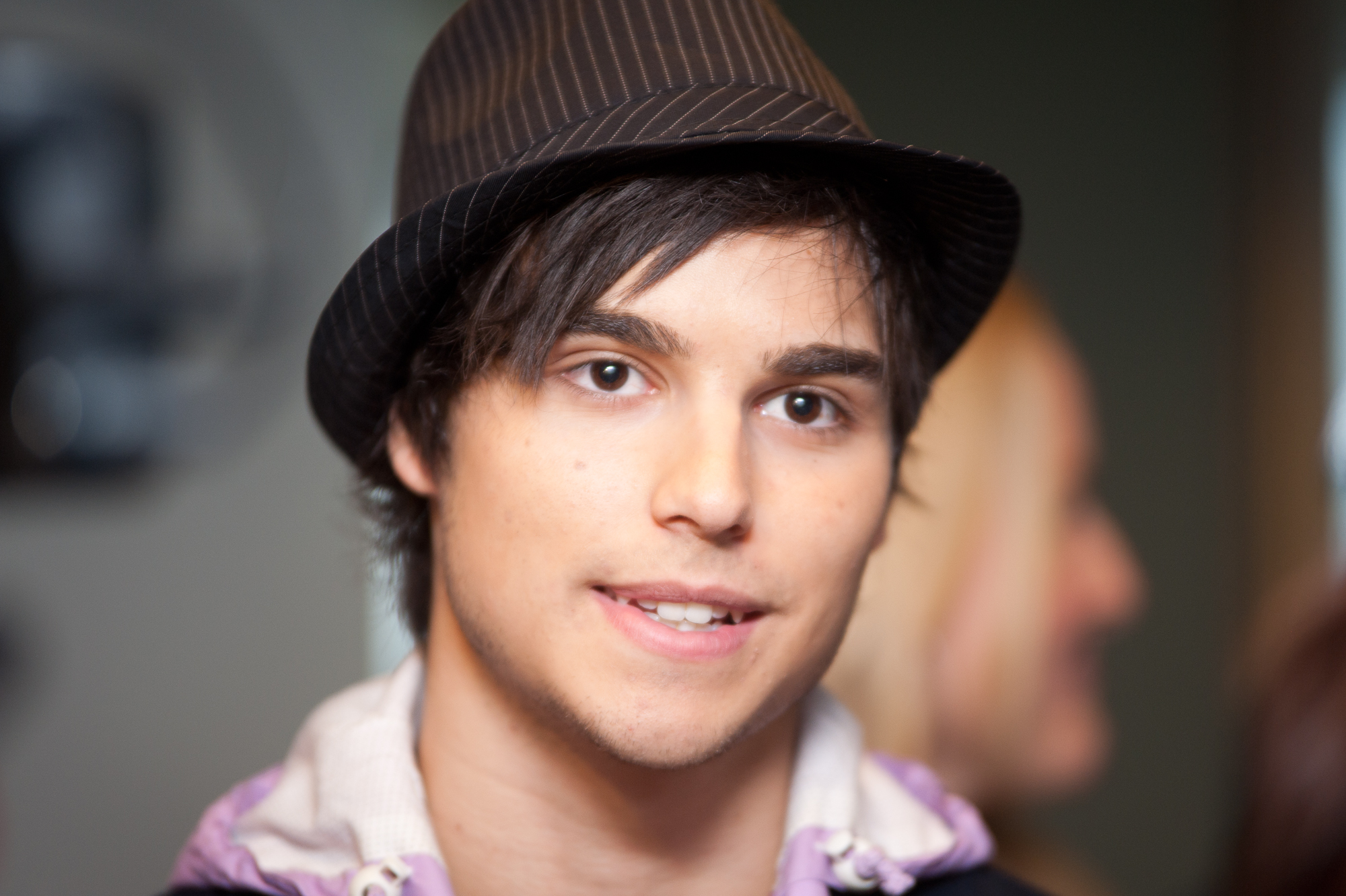 a man wearing a black hat and purple shirt