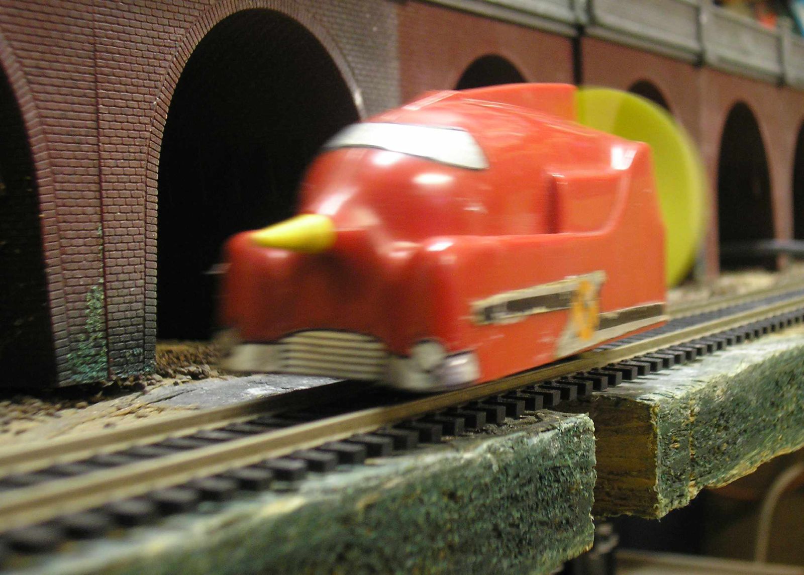 a train is riding down the tracks with toy cars
