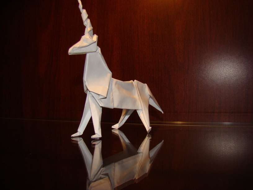 a paper horse standing up on a shiny surface