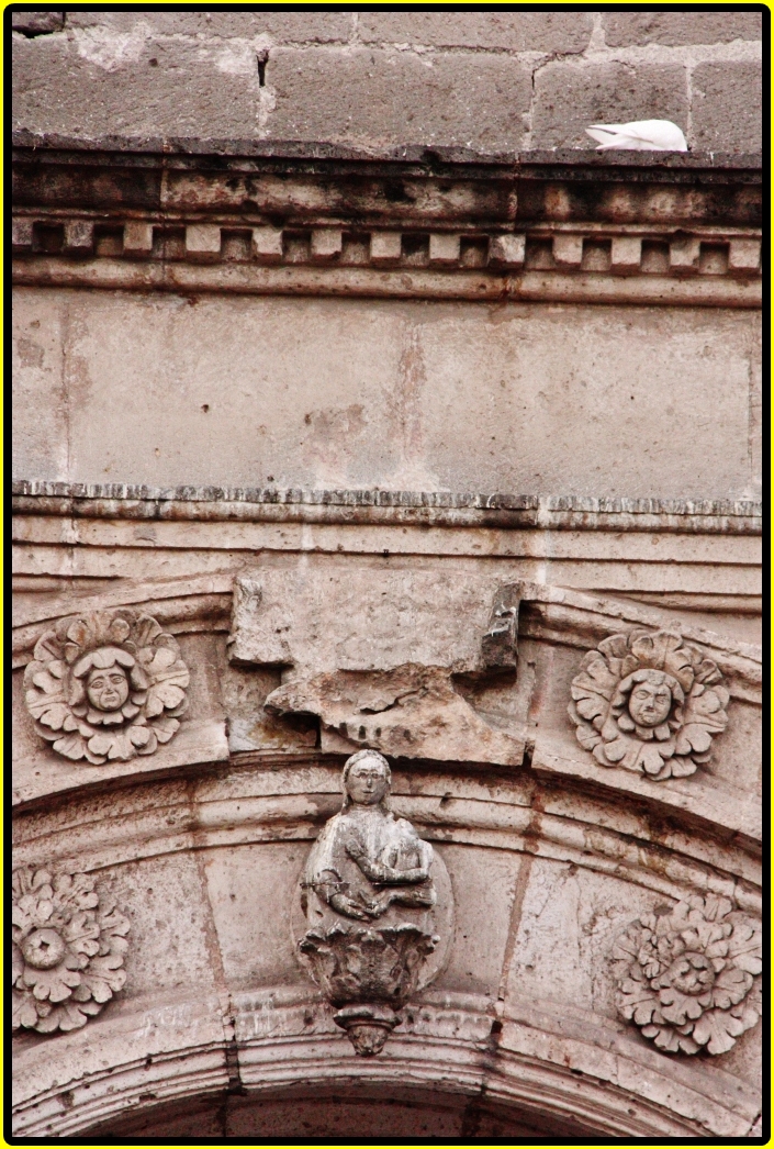 a statue that is sitting on the side of a building