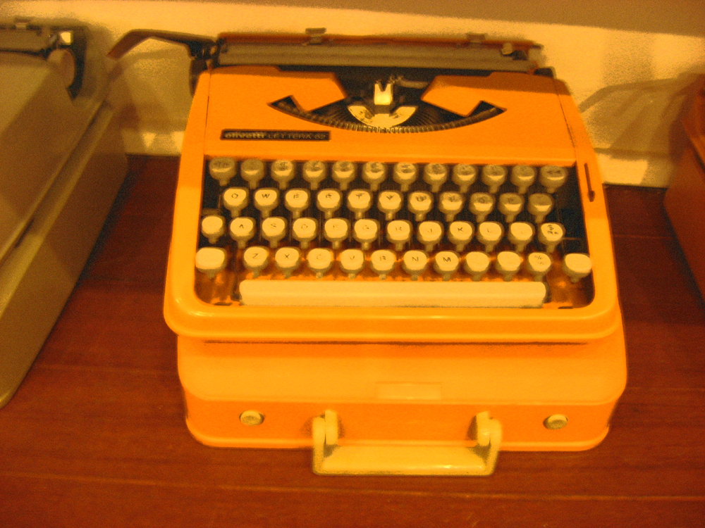 a yellow old fashioned typewriter sitting on a table