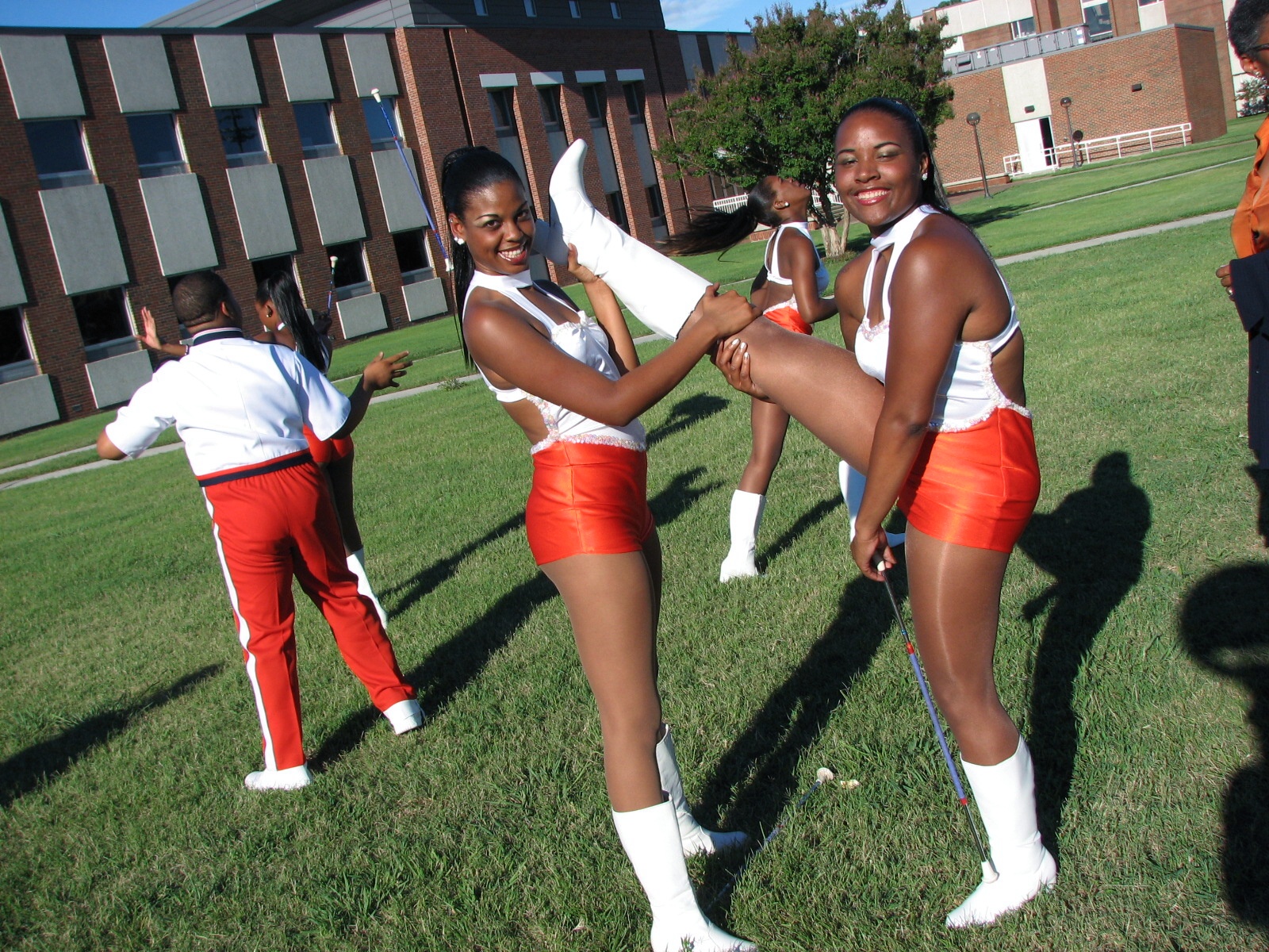 a group of cheerleaders in the grass dancing