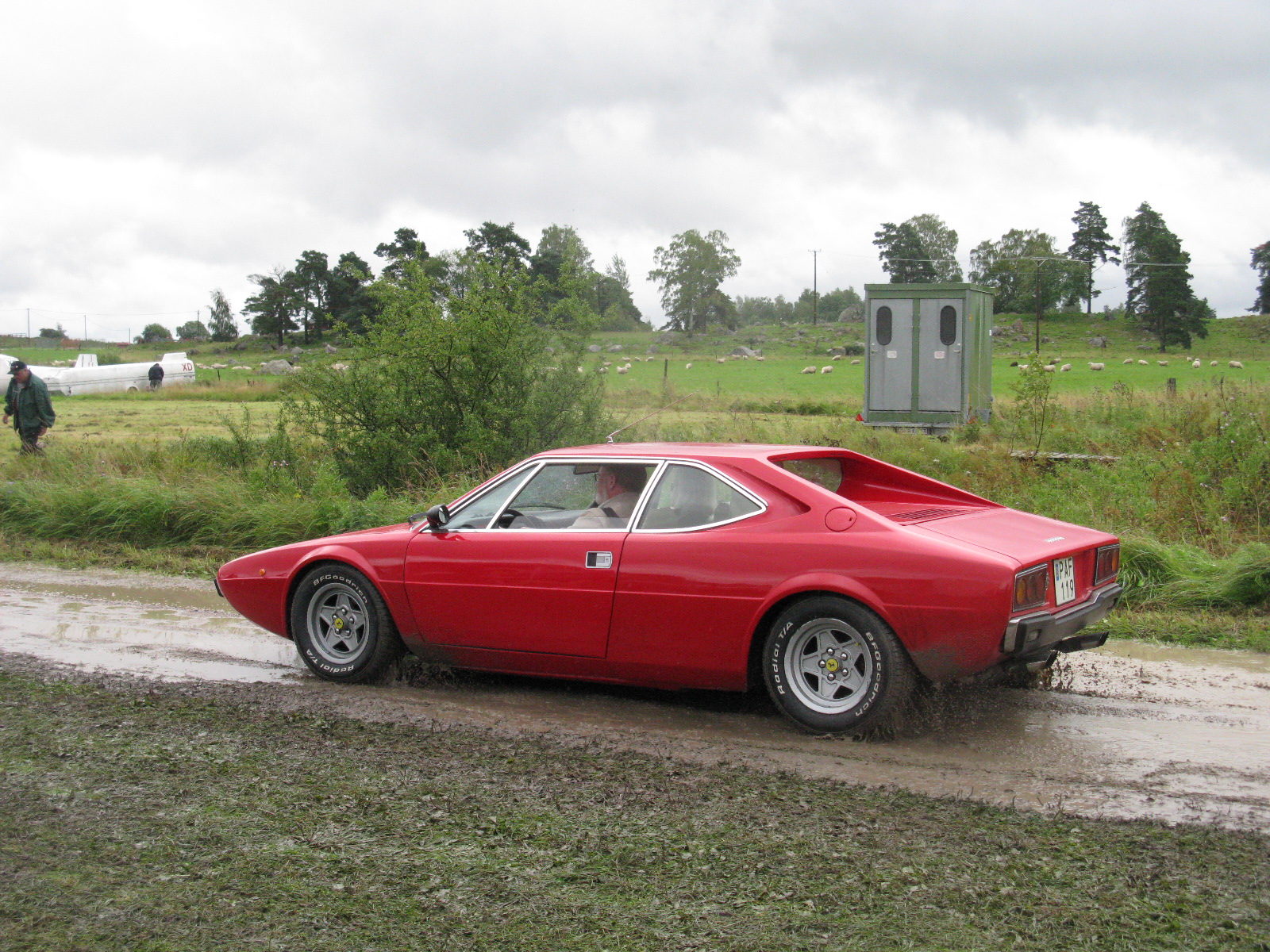 the red car has been parked by the side of the road