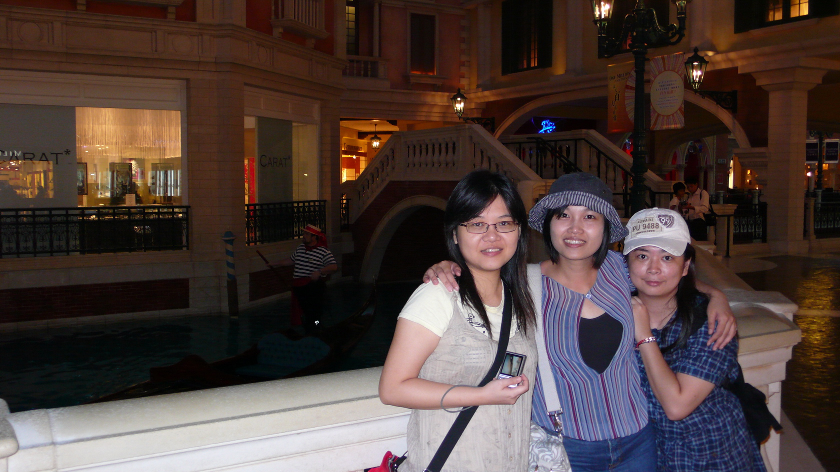 three women standing in front of a fountain at night