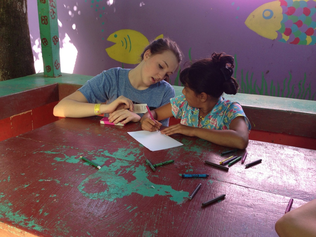 two girls are coloring in the classroom at the table