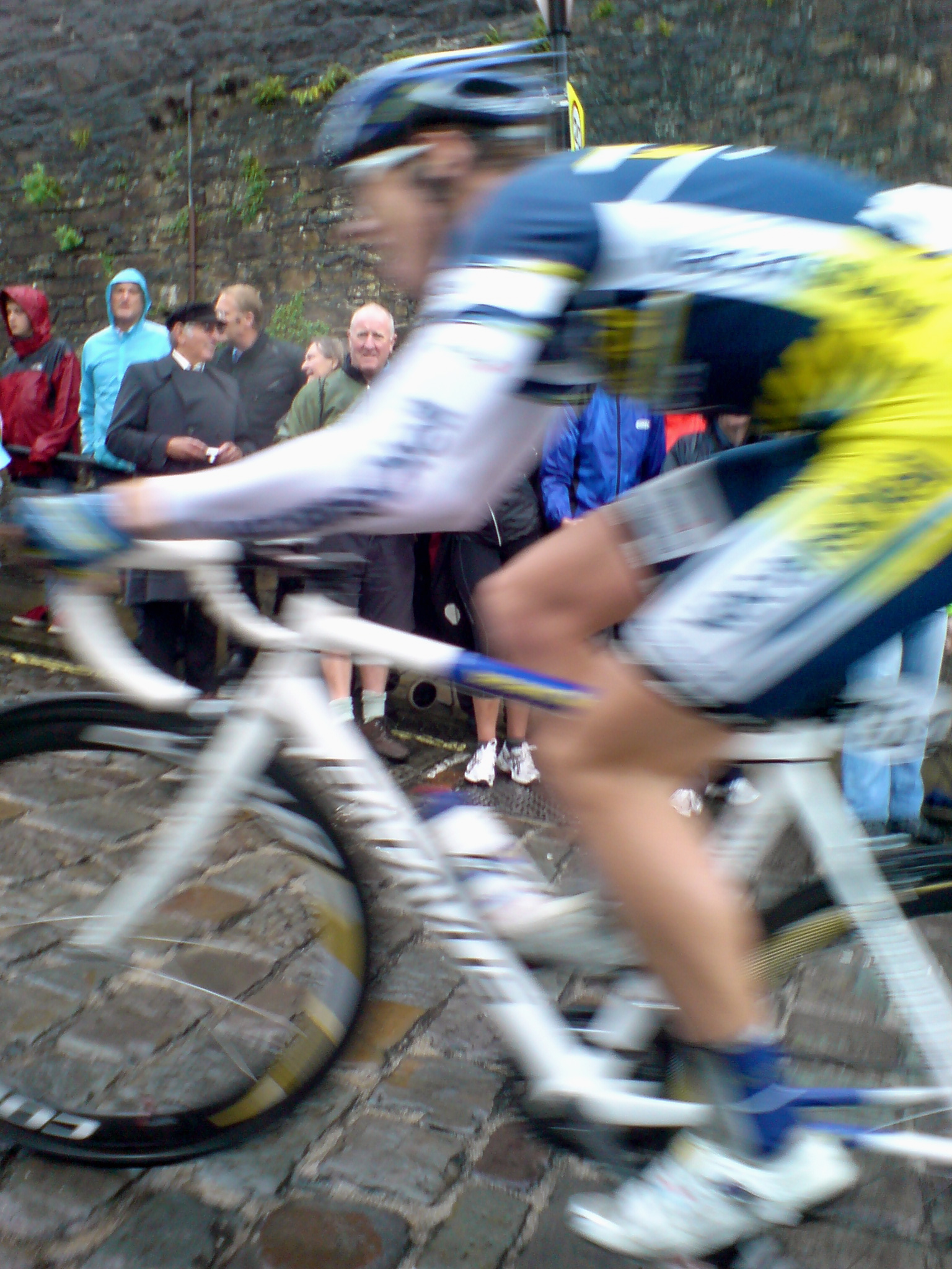 the bicyclist is racing in front of a large crowd