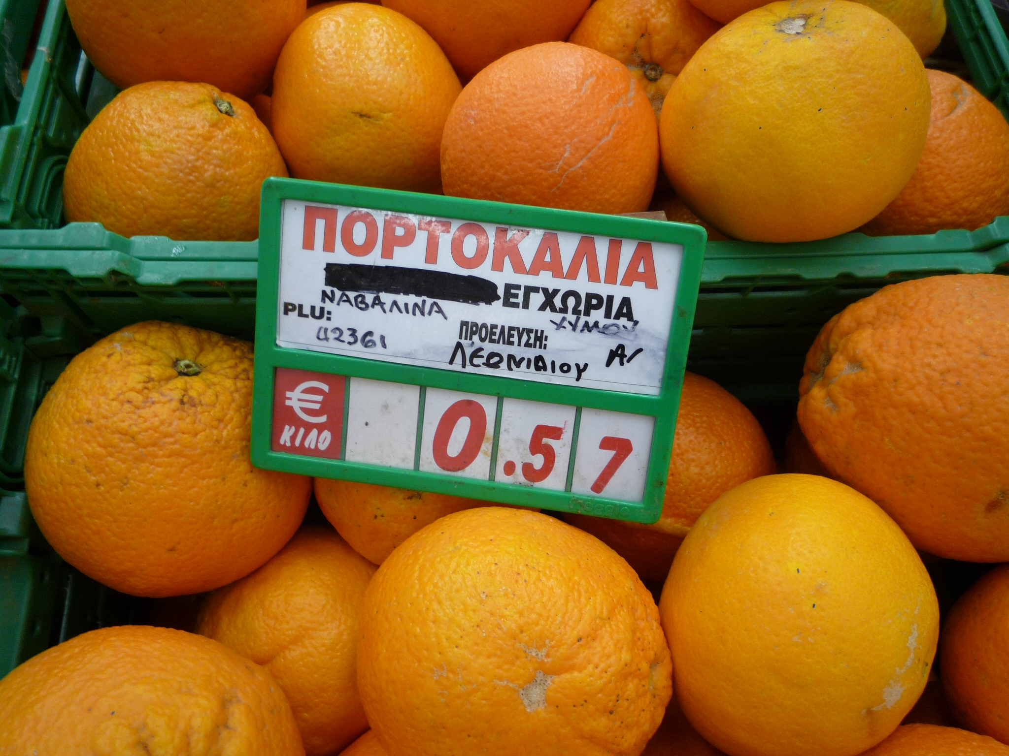 many oranges with price tag on the top for sale