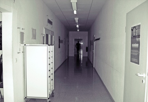 a long hallway with refrigerators on the other side
