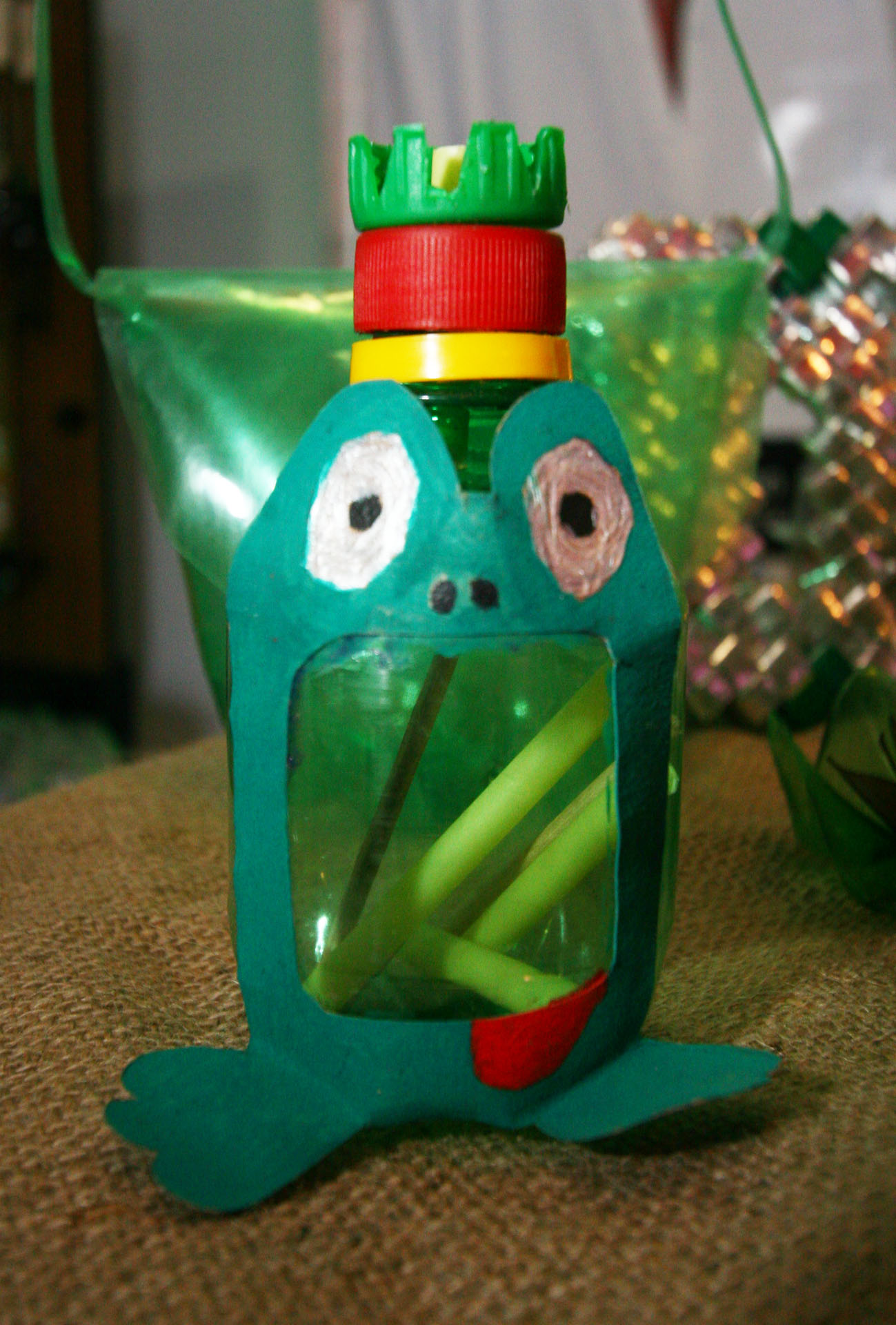 a green toy has a frog in the bottle