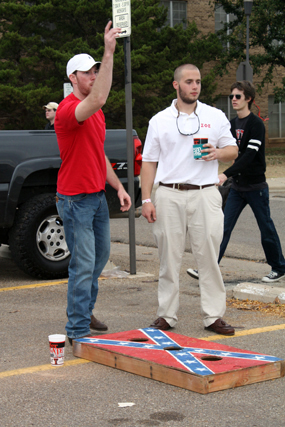 two men in a parking lot with a man standing next to a flying disk