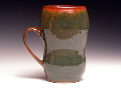 this is a hand made, multi - color coffee cup with the top section of the mug as a camouflage pattern
