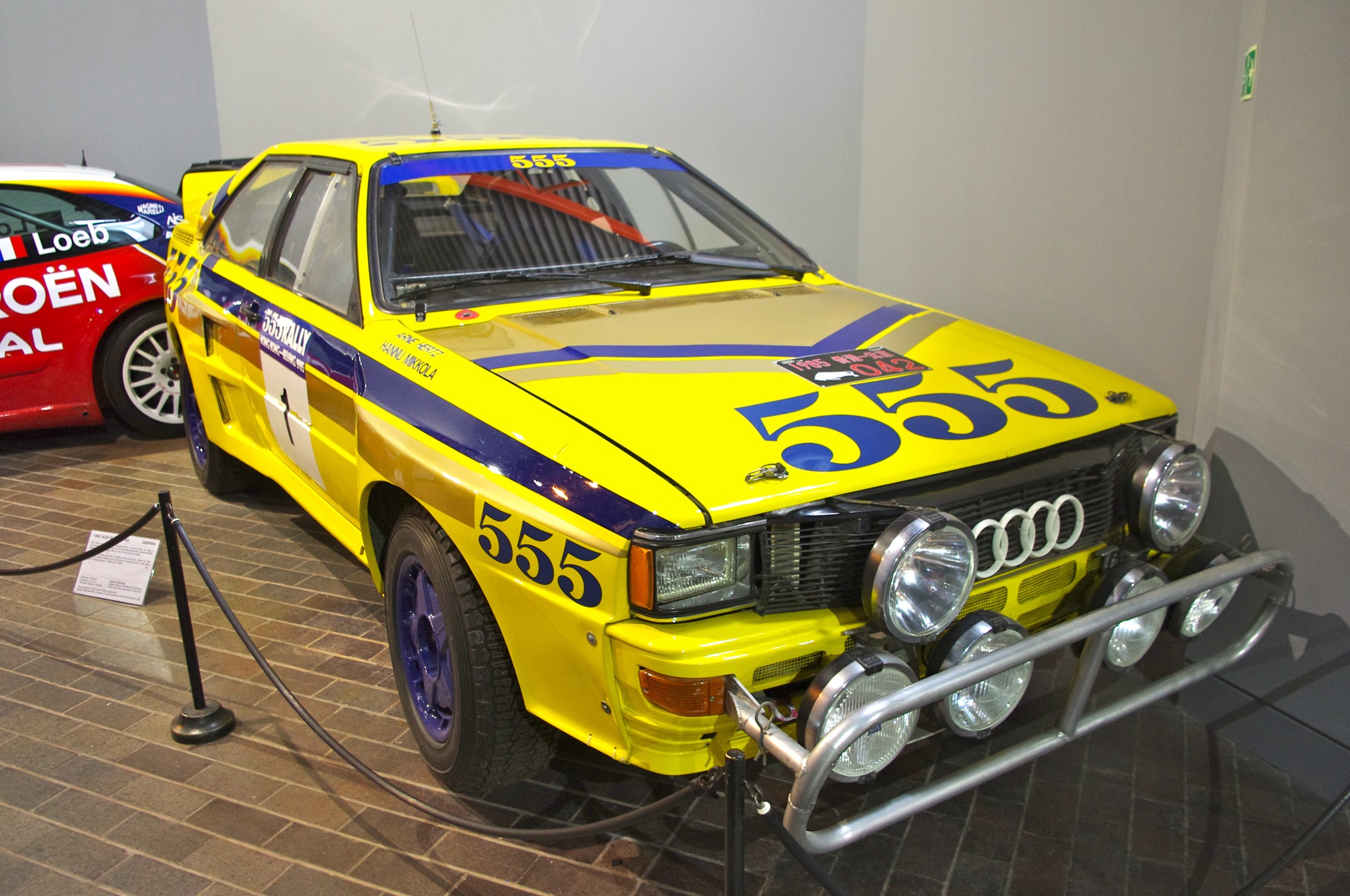a yellow and blue car on display in a museum