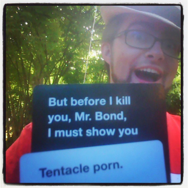 a picture of a man with glasses and a sign saying, but before i  you, mr bond, i must show you tenacle porn
