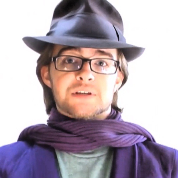 a man in a purple suit and hat