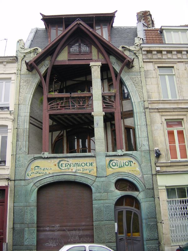 an old green building with ornate iron work