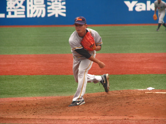 a man in a grey baseball jersey is throwing a ball