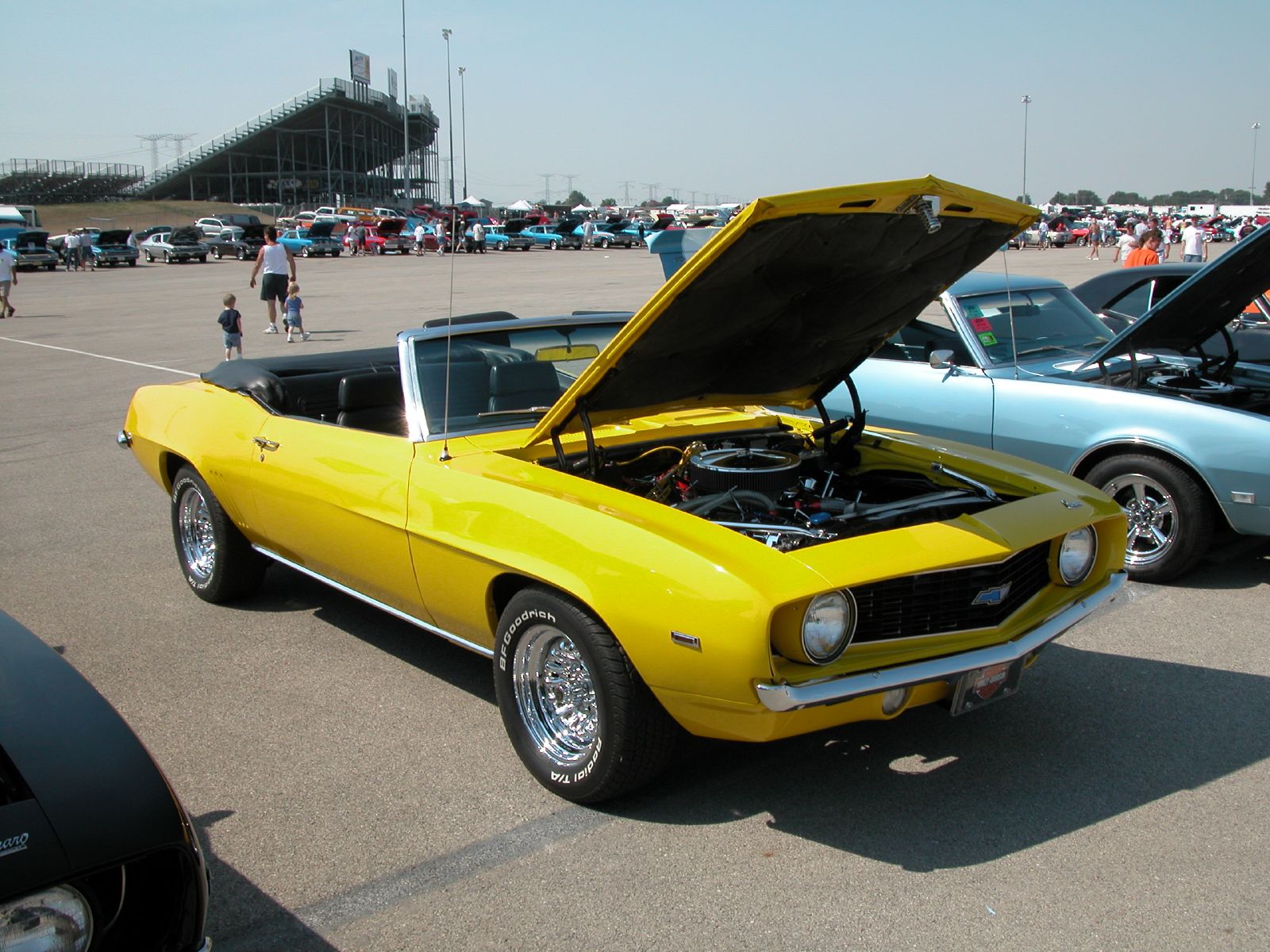 several old model cars on display in a parking lot