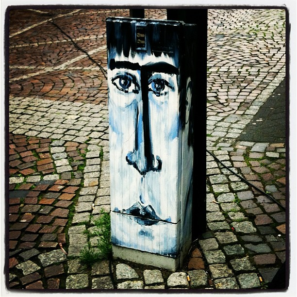 a large head has been painted on the concrete of the sidewalk