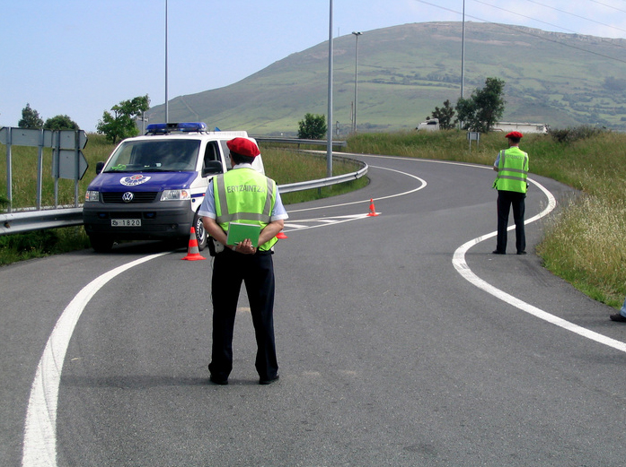a police officer on the side of the road next to a van