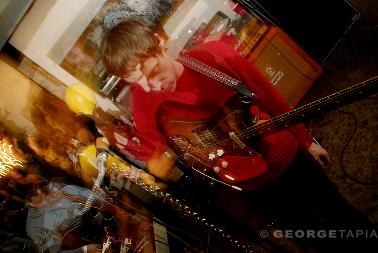 the young man in the red sweater is playing an electric guitar