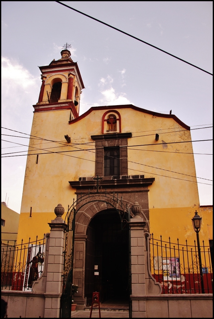 a church in a town with a steeple and gate