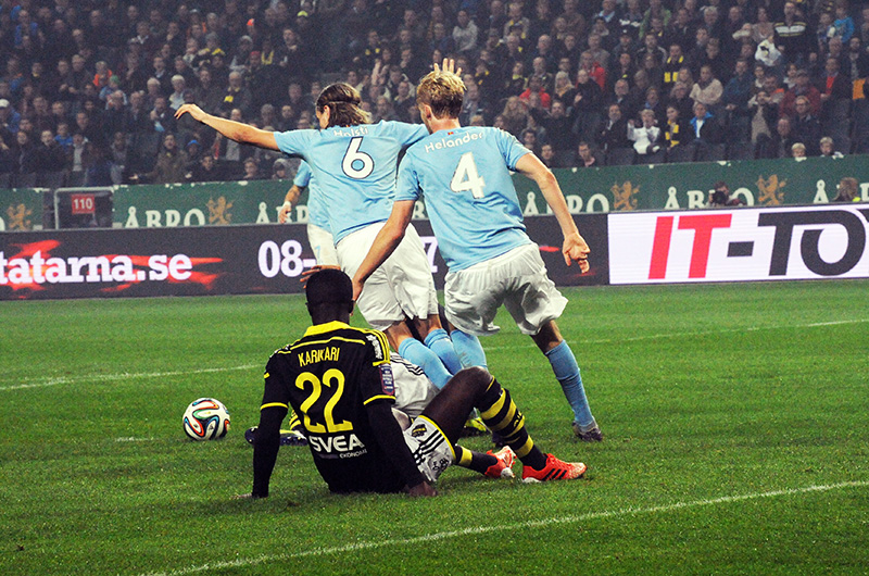 players in action during a soccer game with fans watching