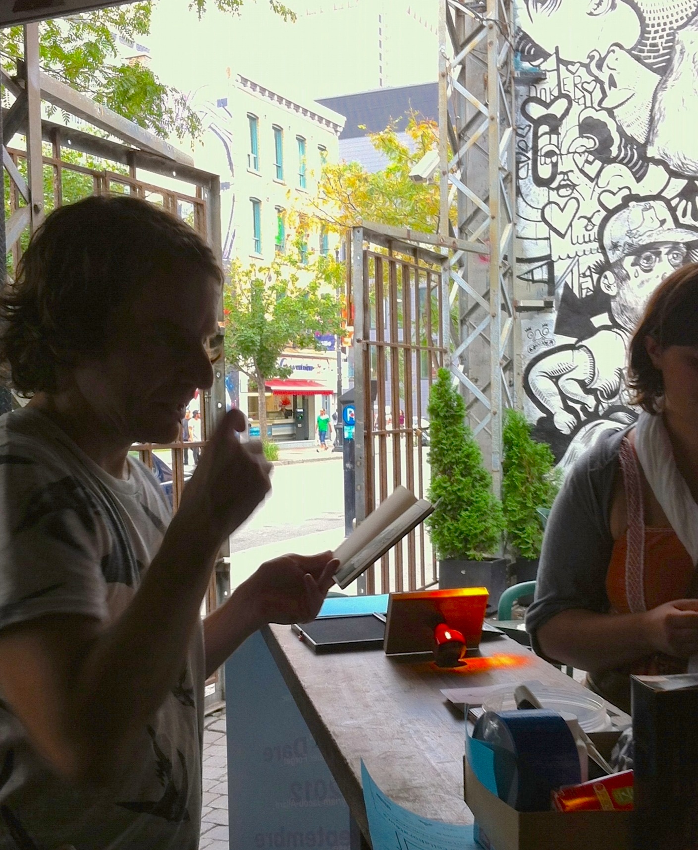 two women stand and look at soing at an outdoor eatery