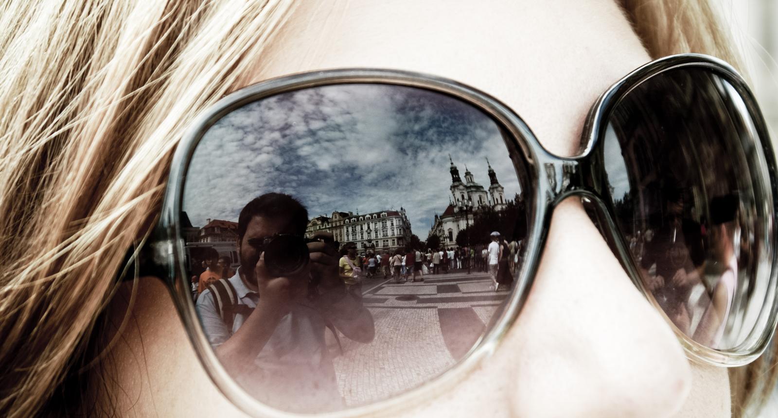 a reflection in sunglasses of some people in front of them