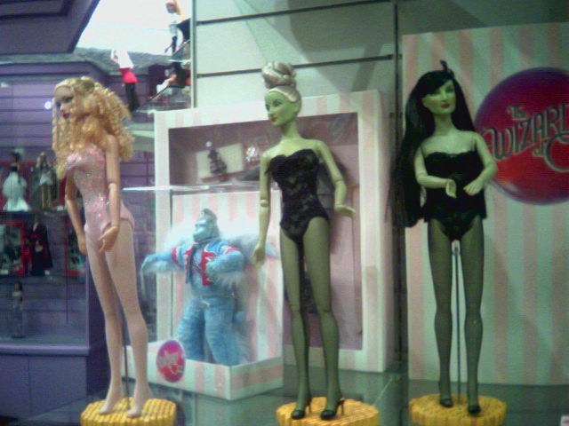several doll and barbie items are being displayed on racks
