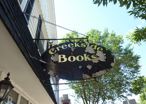 a black sign advertising the greenwich book store