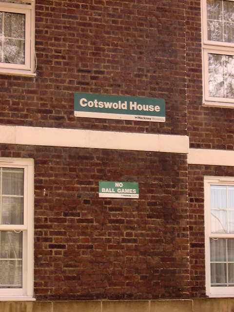 street signs in front of brick building and two windows
