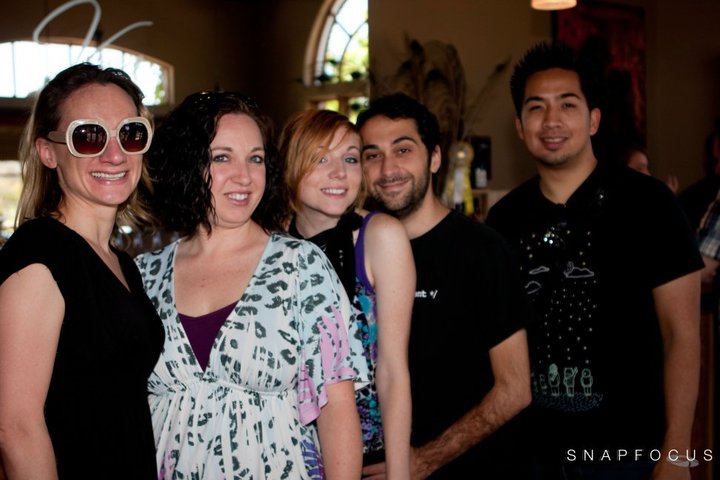 group of friends at an event, with three woman and four men posing for the camera