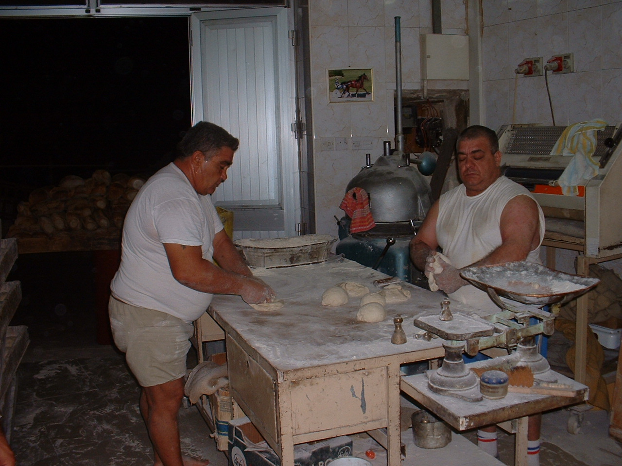 three men are in the kitchen making doughs