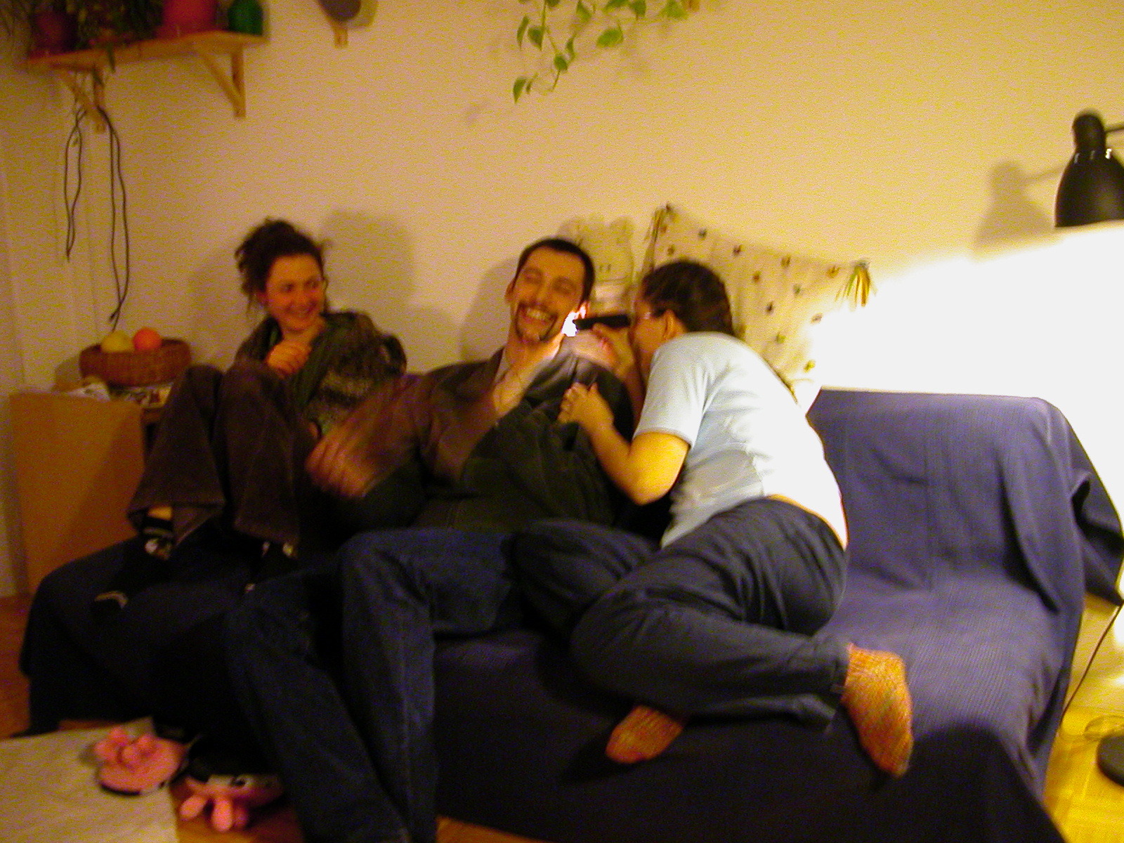 three people sitting on a bed in a room