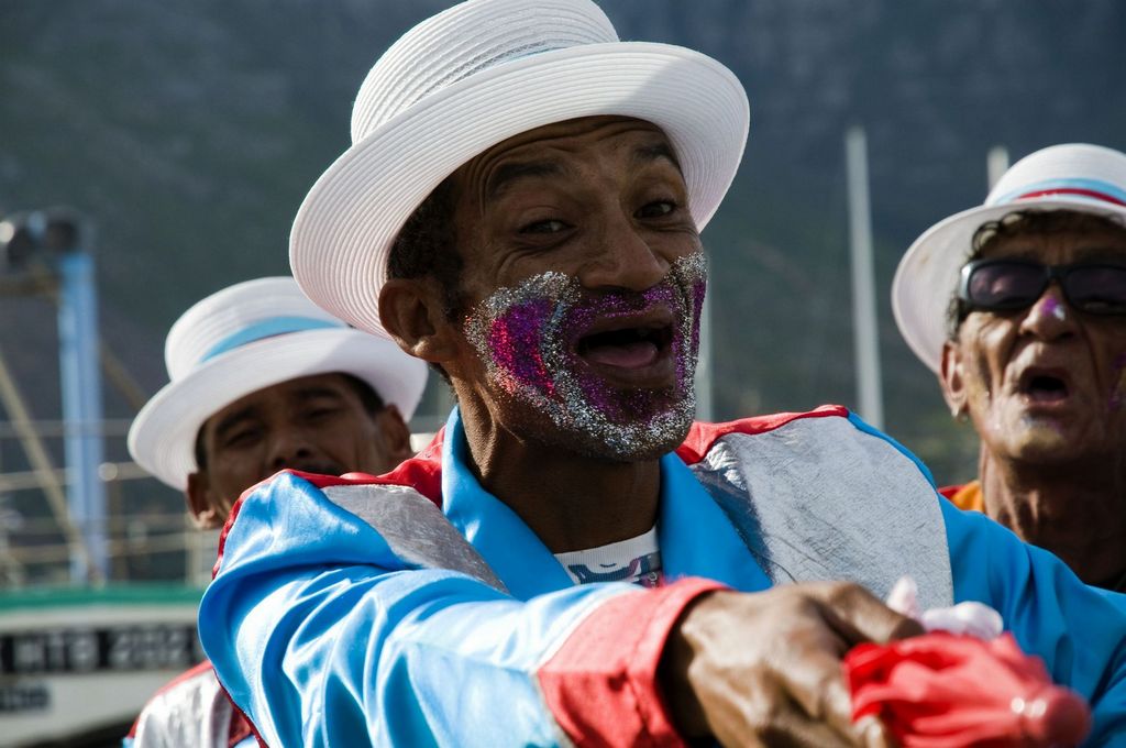 a group of people wearing costumes and hat with their faces painted