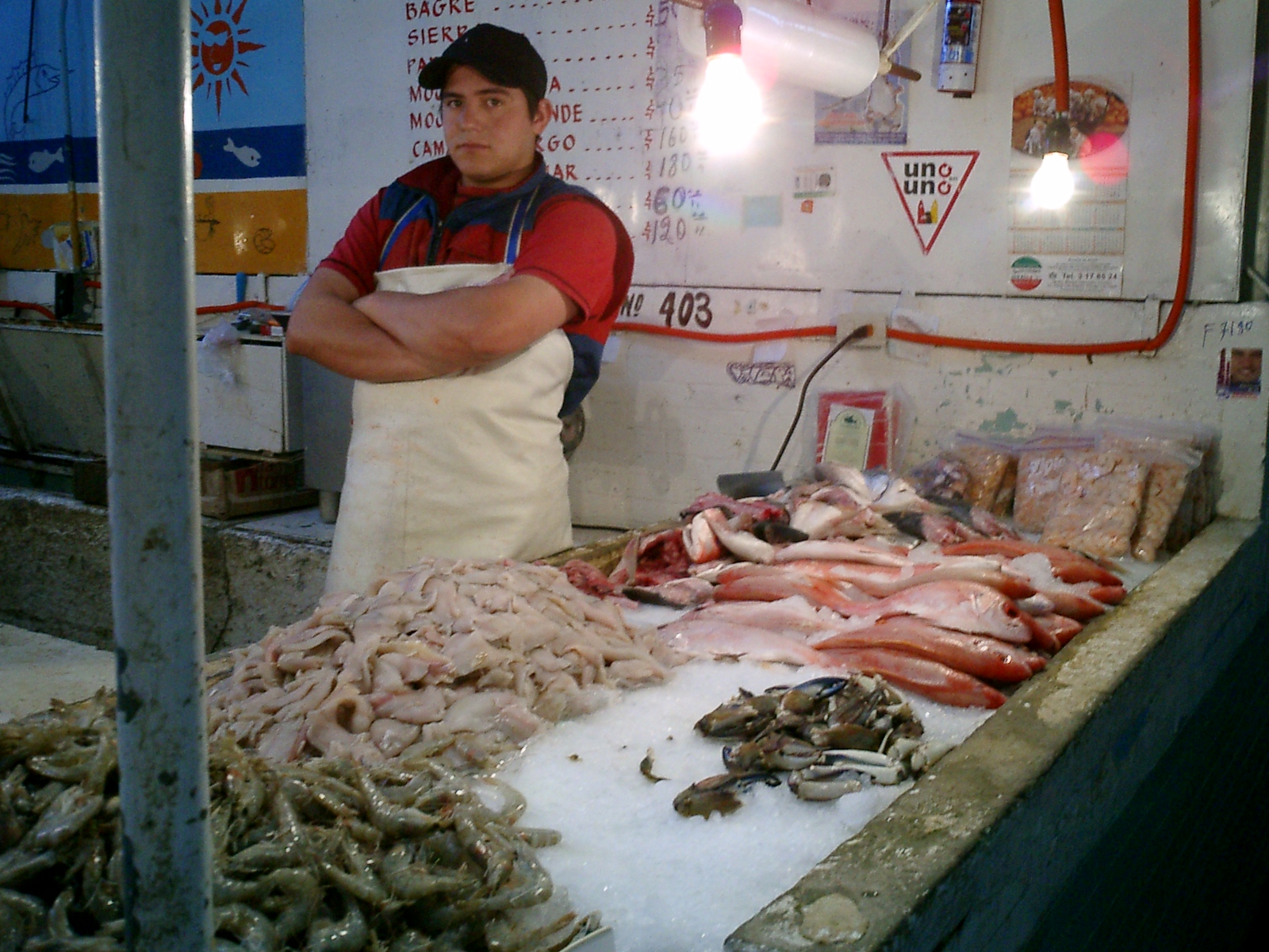 an employee stands in front of a counter of seafood