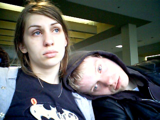 young couple resting near airport terminal waiting for ride