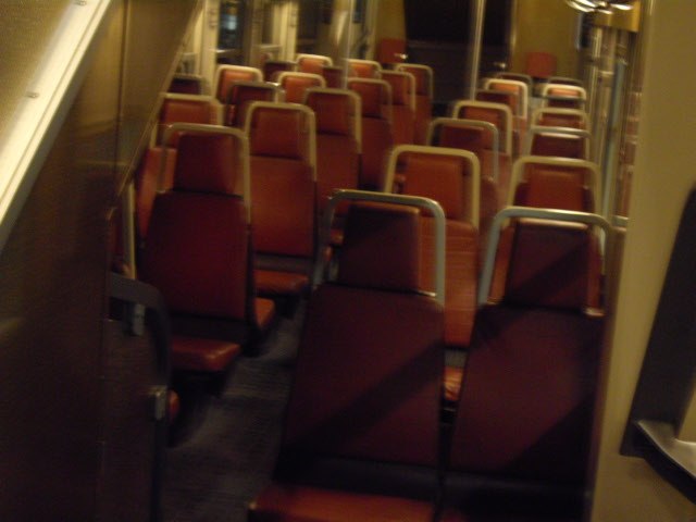 view from the seat on a commuter train with red seats