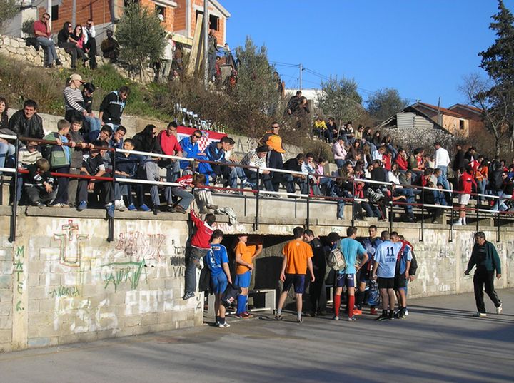 the crowd of people watch the people perform on their skateboards