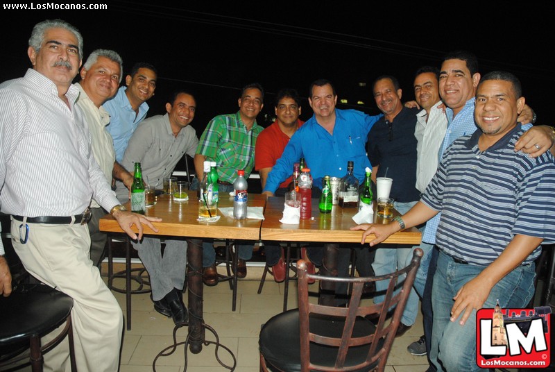 a group of people sitting around a wooden table