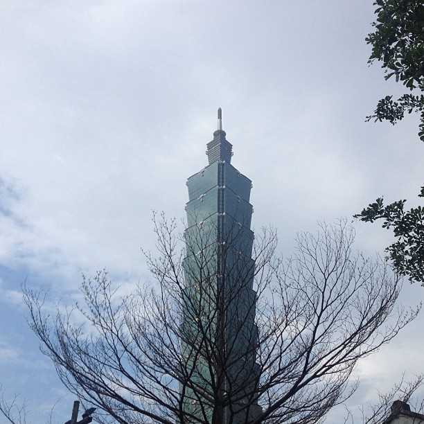 a tall building with a spire stands near trees