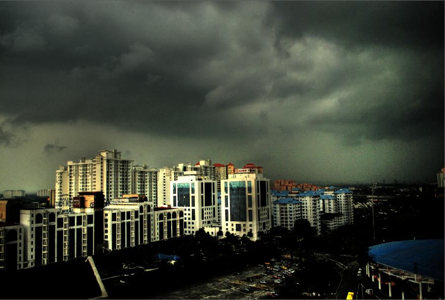 the city with dark storm clouds looms in the background